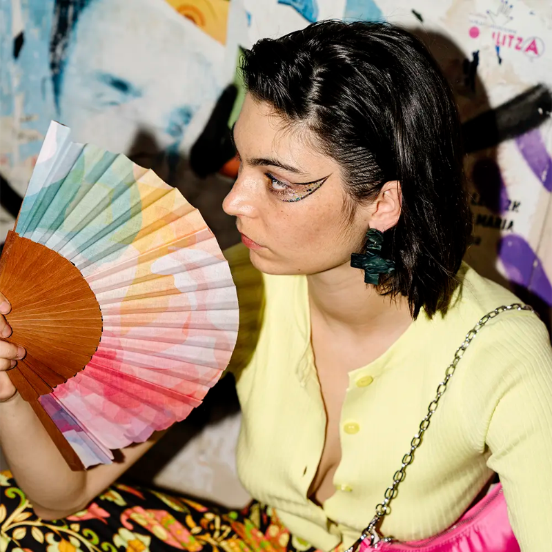 Woman holding a color swatch fan with a colorful background