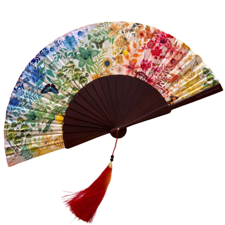 Colorful floral-patterned hand fan with a red tassel on a multicolored background